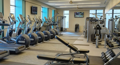 Expansive fitness center at AMLI River North, fully equipped with modern cardio machines and a wide array of weights