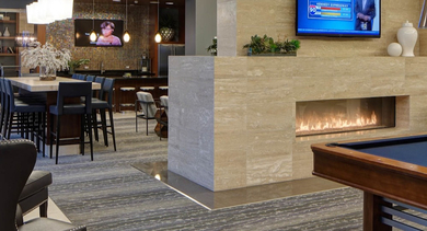 Vibrant game room at AMLI River North with a billiards table, multiple seating areas, and a cozy fireplace