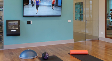 Modern fitness studio at AMLI River North, equipped for various workouts, including a dedicated area for yoga and Pilates