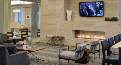 Elegant resident lounge at AMLI River North, featuring a cozy fireplace, comfortable sofas, and a long communal table