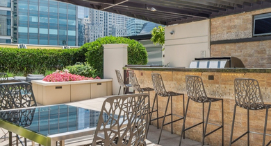 Stylish rooftop kitchen and bar area at AMLI River North, complete with barstools and city views, perfect for entertaining