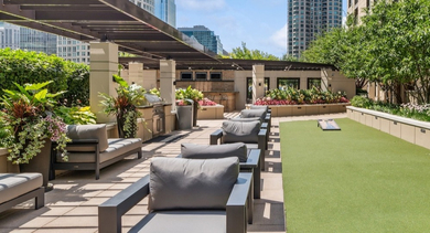 Beautiful rooftop lounge at AMLI River North, complete with comfortable seating, grilling stations, and lush landscaping