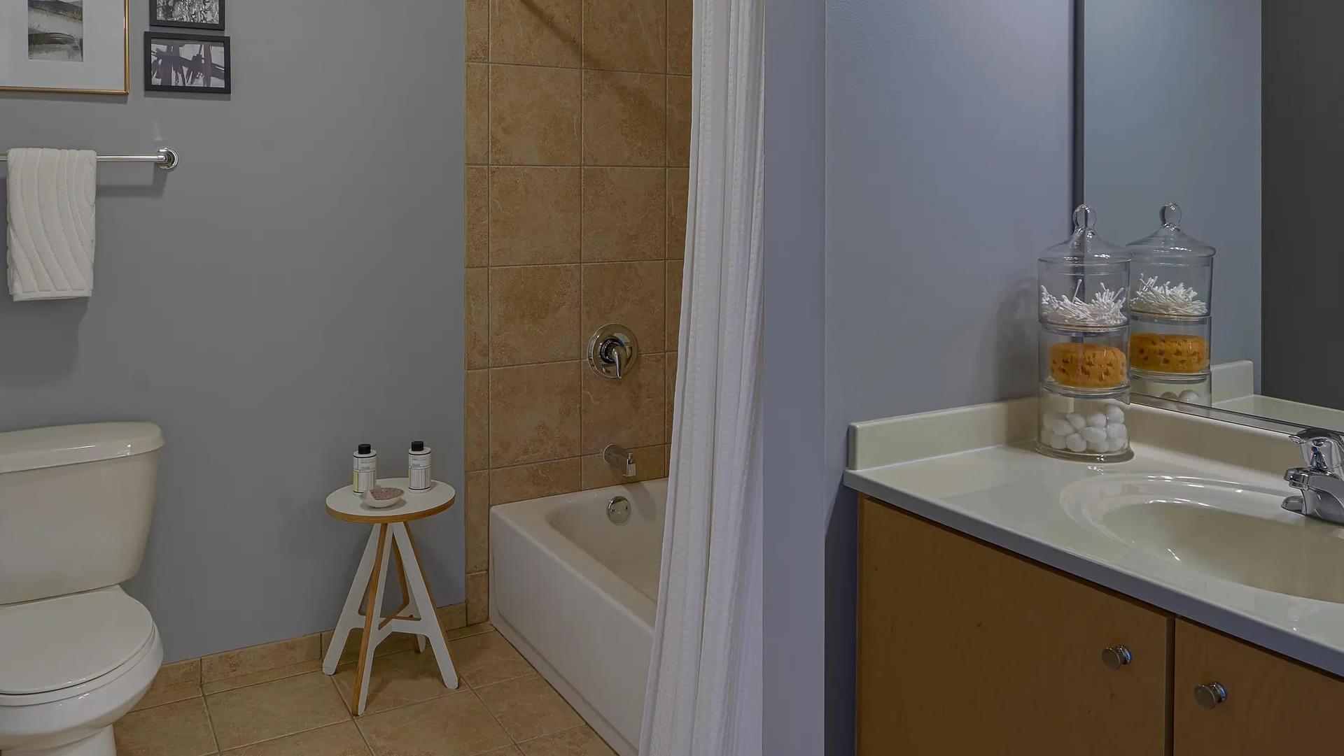 Modern bathroom with soaking tub and tiled surround, single vanity, and soft gray walls at Aqua at Lakeshore East Apartments in Chicago