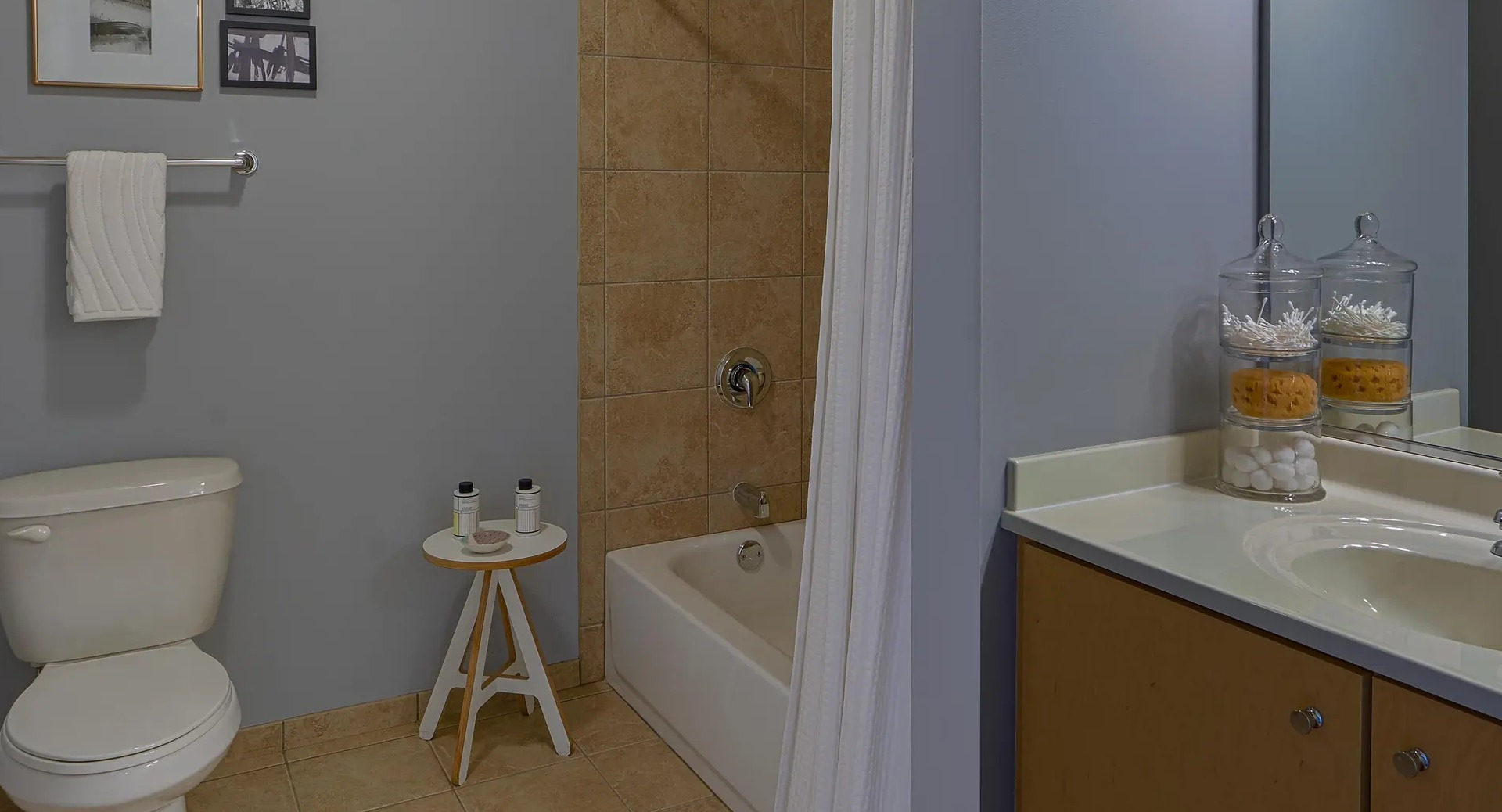 Modern bathroom with soaking tub and tiled surround, single vanity, and soft gray walls at Aqua at Lakeshore East Apartments in Chicago