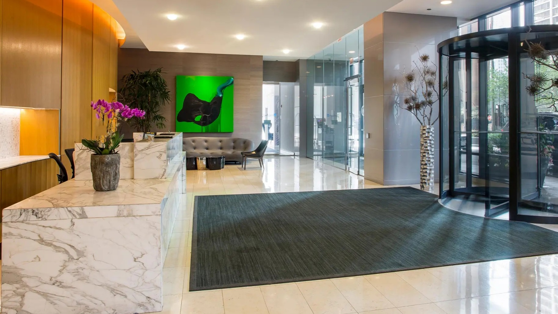 Elegant lobby with marble reception desk, modern art, and stylish seating at Aqua at Lakeshore East Apartments in Chicago