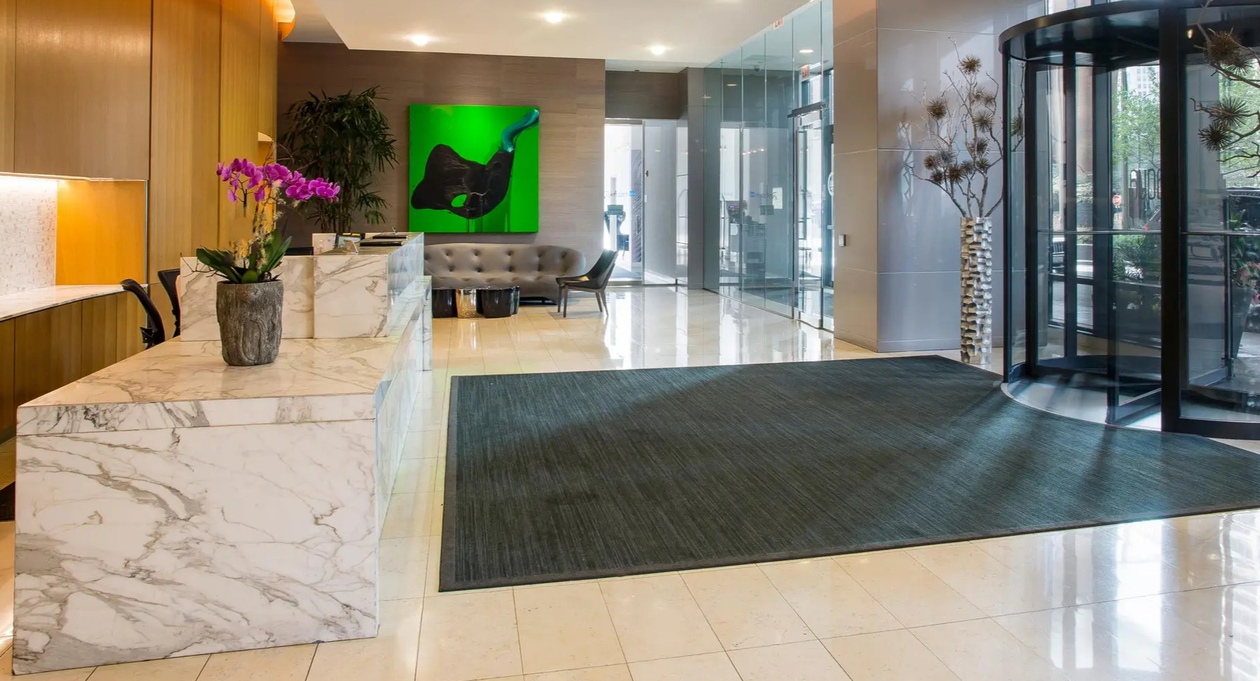 Elegant lobby with marble reception desk, modern art, and stylish seating at Aqua at Lakeshore East Apartments in Chicago