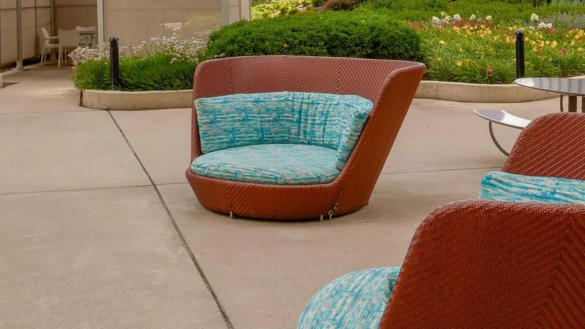 Outdoor deck with round cushioned chairs, skyline views, and landscaped greenery at Aqua at Lakeshore East Apartments in Chicago