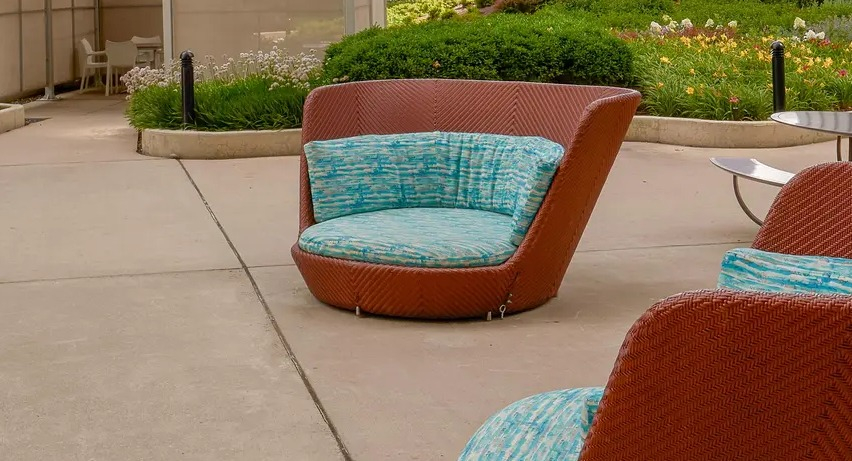 Outdoor deck with round cushioned chairs, skyline views, and landscaped greenery at Aqua at Lakeshore East Apartments in Chicago