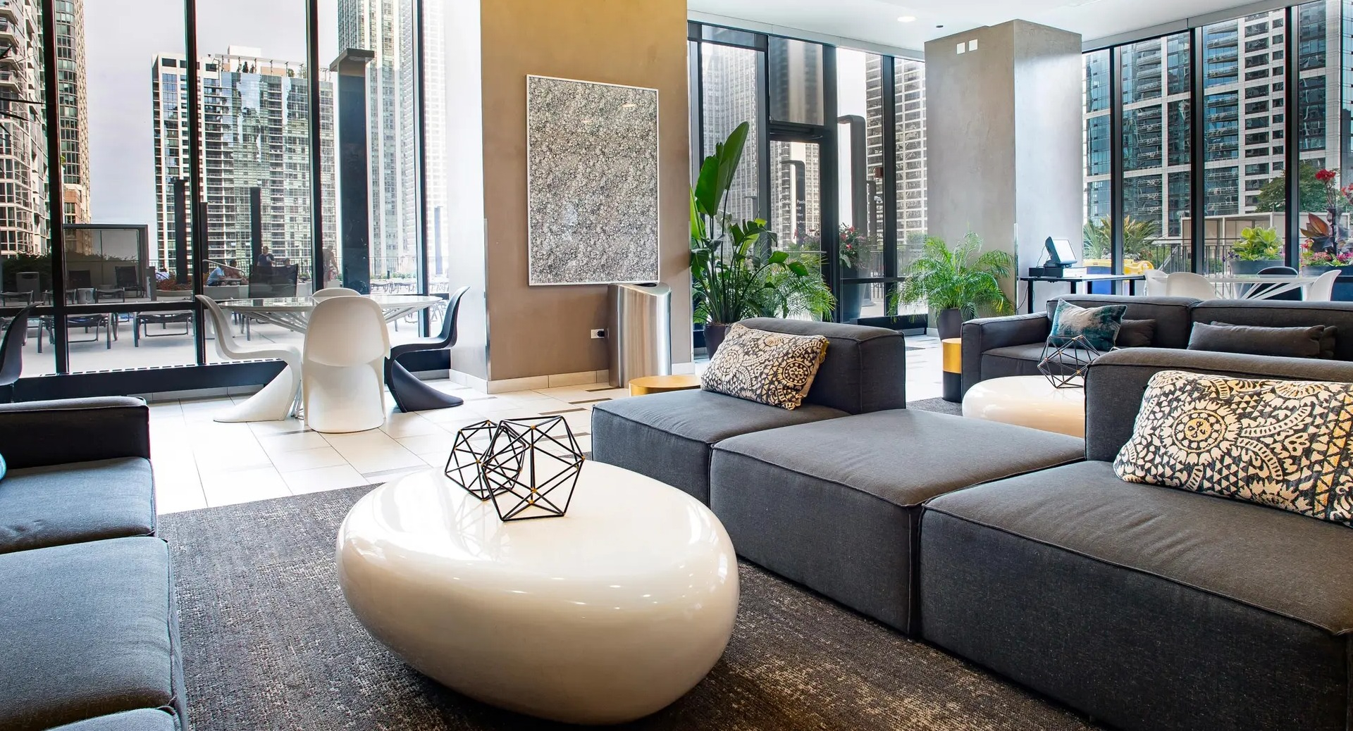 Stylish resident lounge with modern seating, city views, and floor-to-ceiling windows at Aqua at Lakeshore East Apartments in Chicago