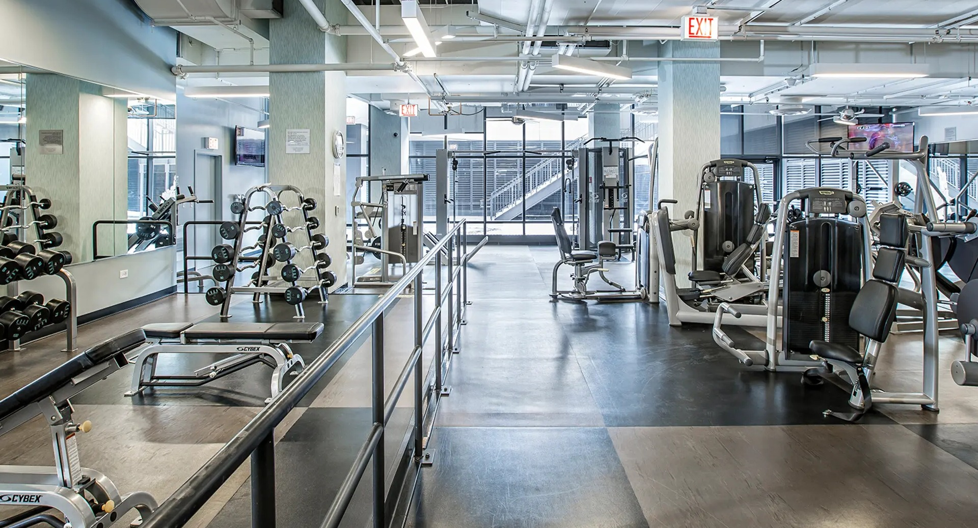 Expansive fitness center with strength and cardio equipment, free weights, and bright studio space at Aqua at Lakeshore East Apartments in Chicago