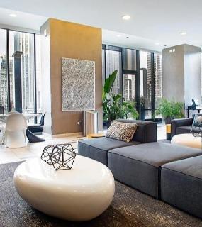 Spacious apartment living area with floor-to-ceiling windows and city views at Aqua at Lakeshore East in Chicago