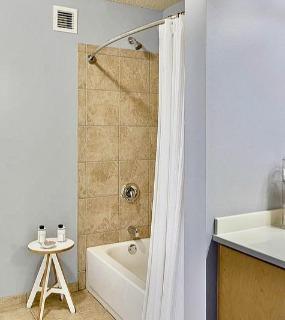 Modern bathroom with a bathtub, elegant decor, and soft lighting at Aqua at Lakeshore East