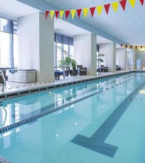 Spacious indoor lap pool with lounge seating and natural light at Aqua at Lakeshore East