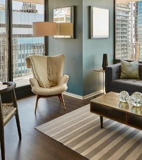 Stylish living room with floor-to-ceiling windows, modern furniture, and city views at Aqua at Lakeshore East