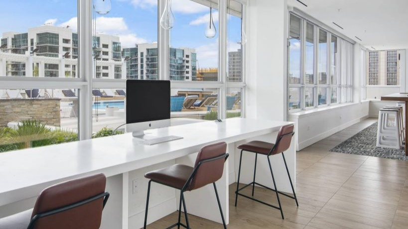 Convenient business center station at Arkadia West Loop with computers, high-top seating, and city views