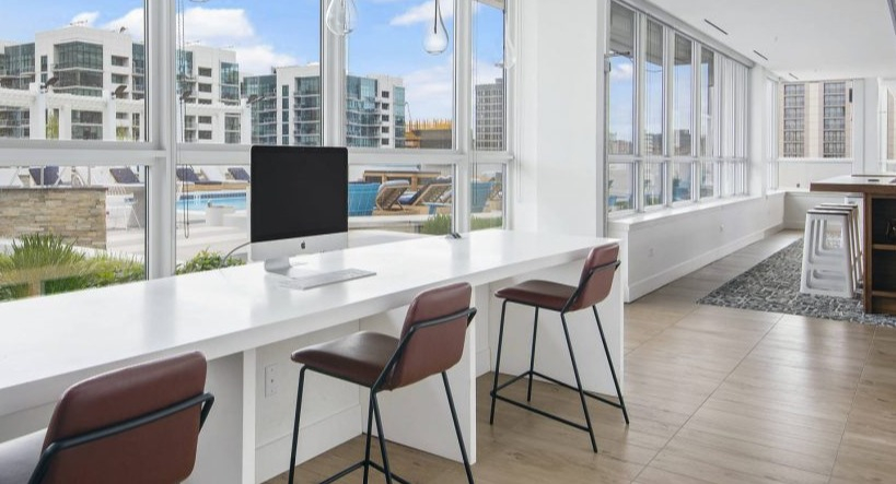 Convenient business center station at Arkadia West Loop with computers, high-top seating, and city views