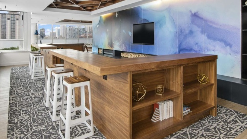 Modern community workspace lounge at Arkadia West Loop with a long communal table and vibrant wall art