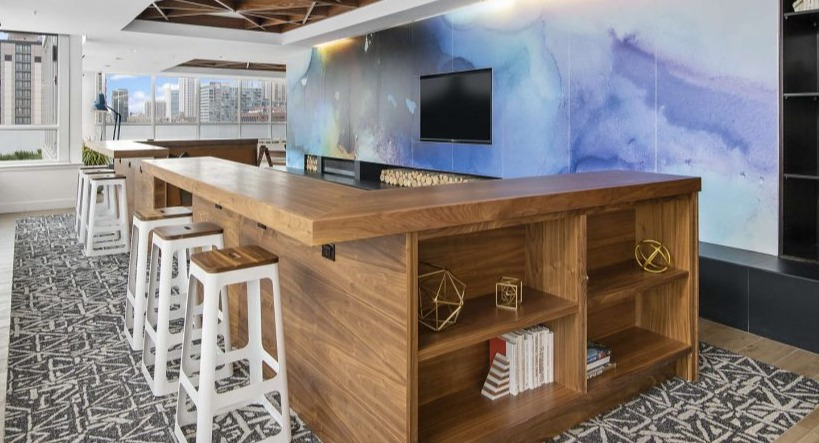 Modern community workspace lounge at Arkadia West Loop with a long communal table and vibrant wall art