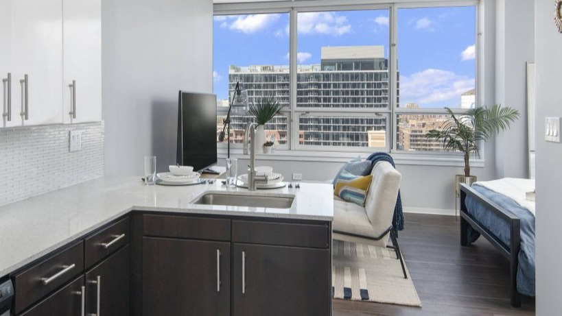 Compact studio kitchen at Arkadia West Loop with contemporary appliances and a bright living/bedroom area
