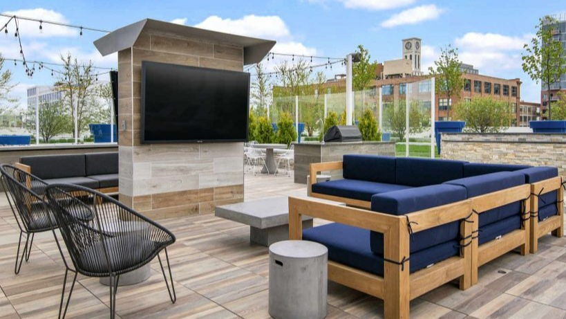 Outdoor entertainment lounge at Arkadia West Loop with comfortable seating and a large screen TV