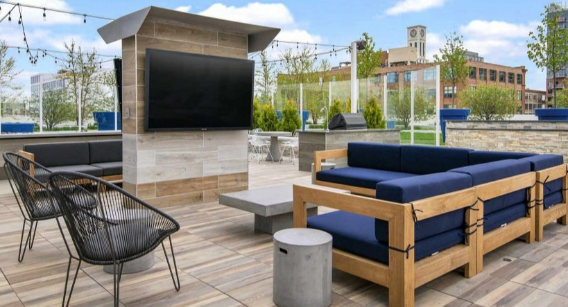 Outdoor entertainment lounge at Arkadia West Loop with comfortable seating and a large screen TV