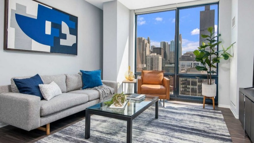 Stylish living room at Arkadia West Loop with a modern sofa, accent chair, and impressive city views
