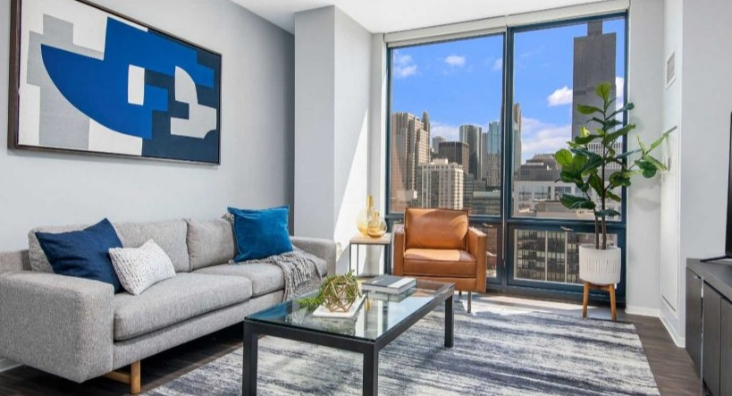 Stylish living room at Arkadia West Loop with a modern sofa, accent chair, and impressive city views