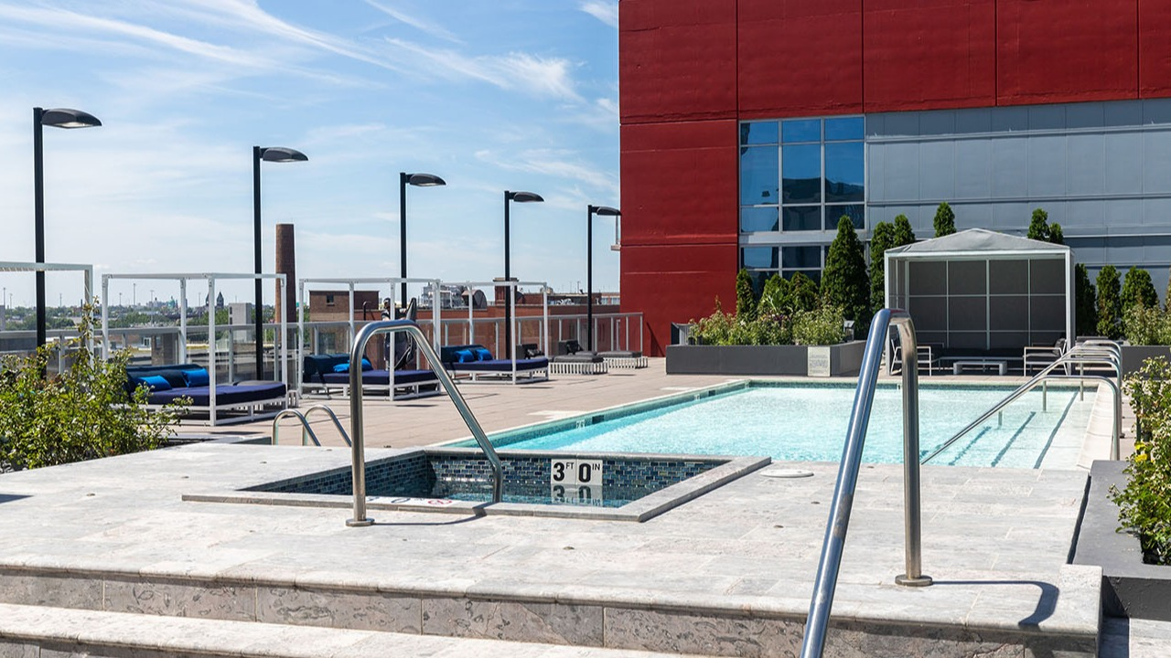 Inviting rooftop swimming pool and hot tub area with lounge seating, offering a refreshing escape at Arrive LEX in Chicago