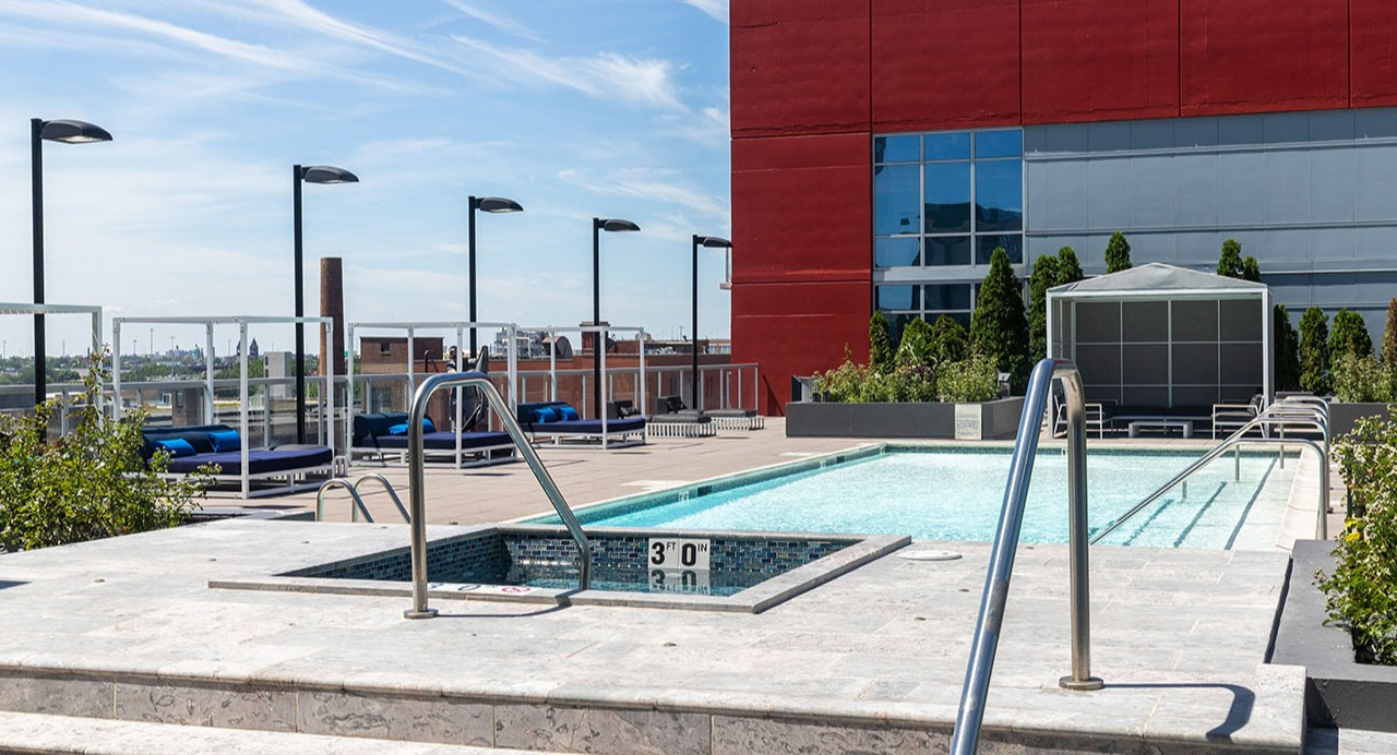 Inviting rooftop swimming pool and hot tub area with lounge seating, offering a refreshing escape at Arrive LEX in Chicago