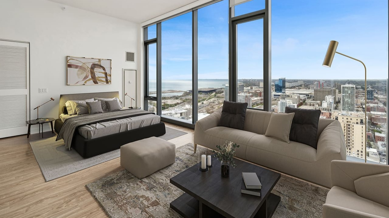 A cozy bedroom with a large window offering panoramic city and lake views at Arrive Michigan Avenue apartments in Chicago