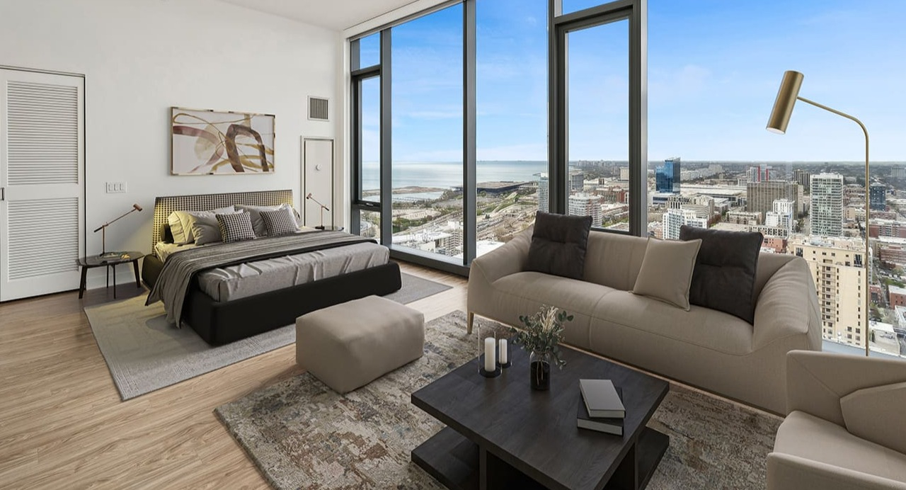 A cozy bedroom with a large window offering panoramic city and lake views at Arrive Michigan Avenue apartments in Chicago