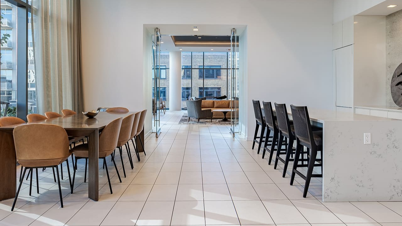 Spacious clubroom with a large dining table and kitchen island, perfect for entertaining at Arrive Michigan Avenue in Chicago