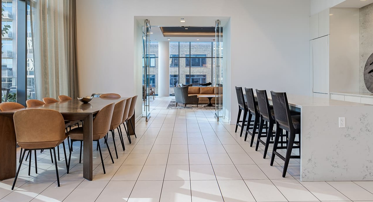 Spacious clubroom with a large dining table and kitchen island, perfect for entertaining at Arrive Michigan Avenue in Chicago