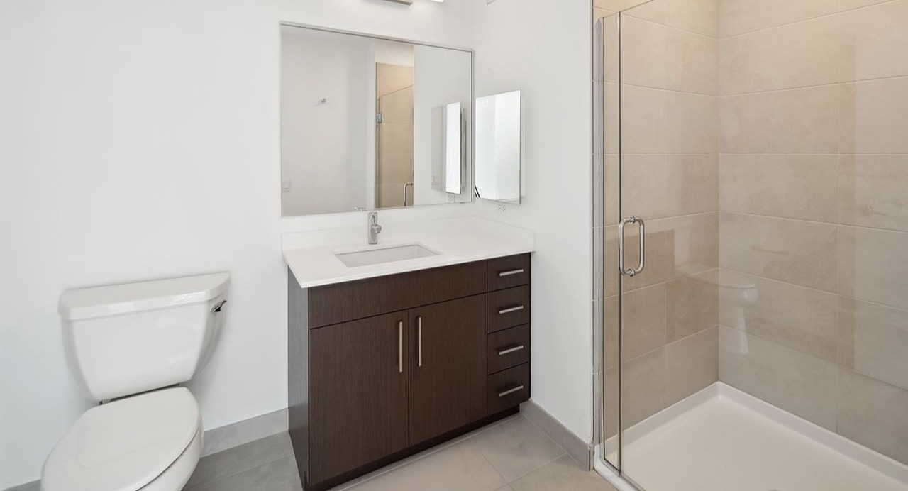 Modern bathroom with a sleek vanity, spacious shower, and clean design at Arrive Michigan Avenue apartments in Chicago
