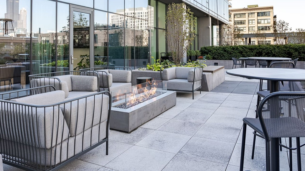 Outdoor patio with a modern fire pit, comfortable seating, and city views at Arrive Michigan Avenue apartments in Chicago
