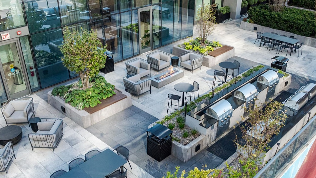 Expansive outdoor amenity deck with grilling stations, lounge seating, and dining areas at Arrive Michigan Avenue apartments in Chicago