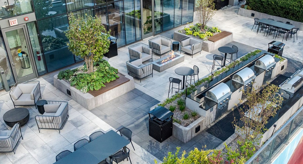 Expansive outdoor amenity deck with grilling stations, lounge seating, and dining areas at Arrive Michigan Avenue apartments in Chicago