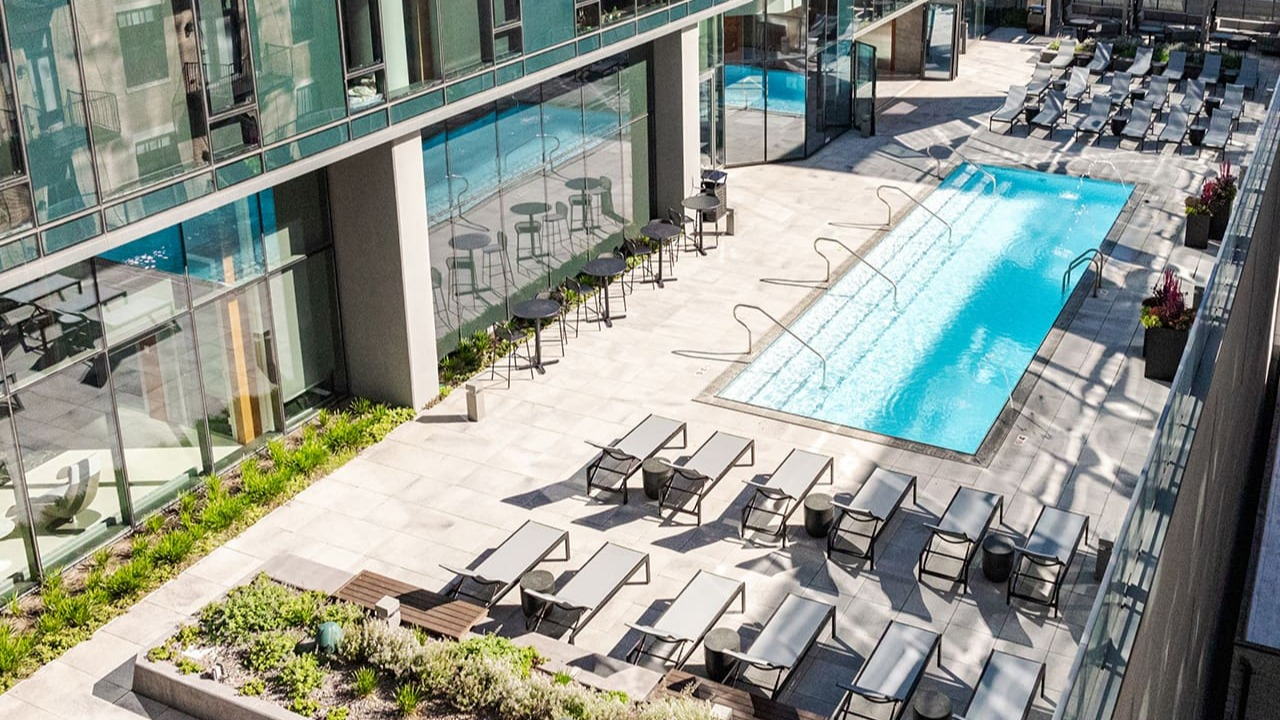 Aerial view of the luxurious rooftop pool deck with lounge seating and modern architecture at Arrive Michigan Avenue in Chicago