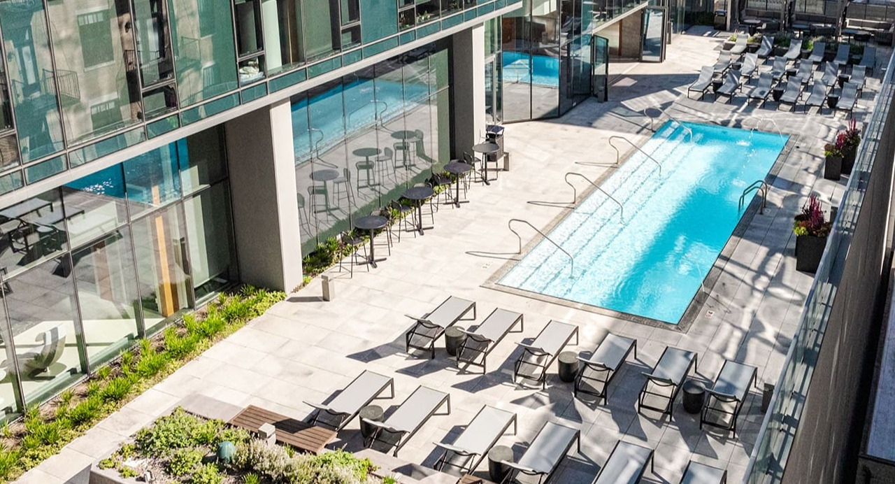 Aerial view of the luxurious rooftop pool deck with lounge seating and modern architecture at Arrive Michigan Avenue in Chicago