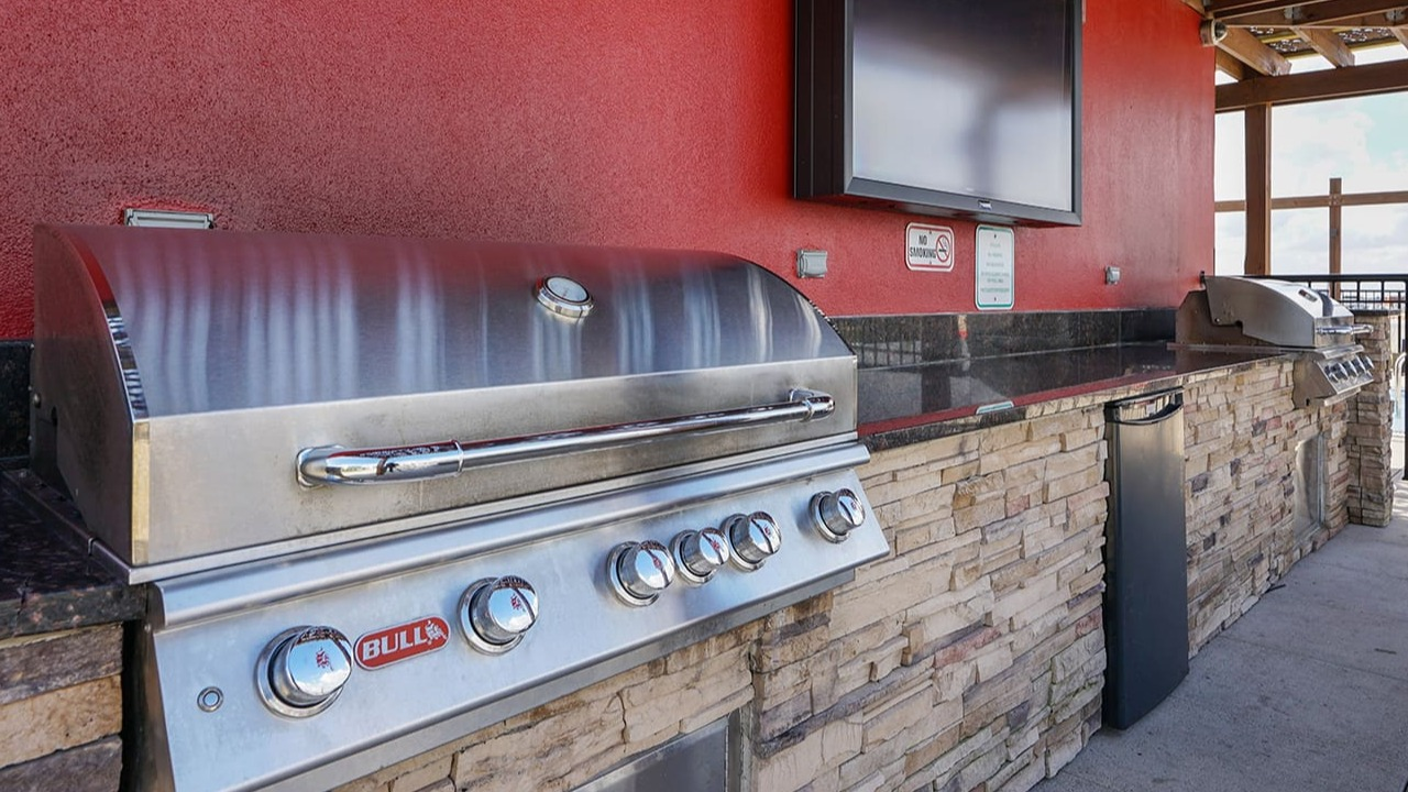 Outdoor grilling station at Arrive South Loop apartments, complete with high-end grills and a television for entertaining in Chicago