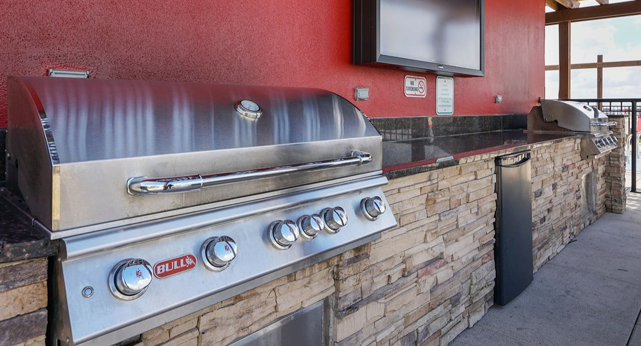 Outdoor grilling station at Arrive South Loop apartments, complete with high-end grills and a television for entertaining in Chicago