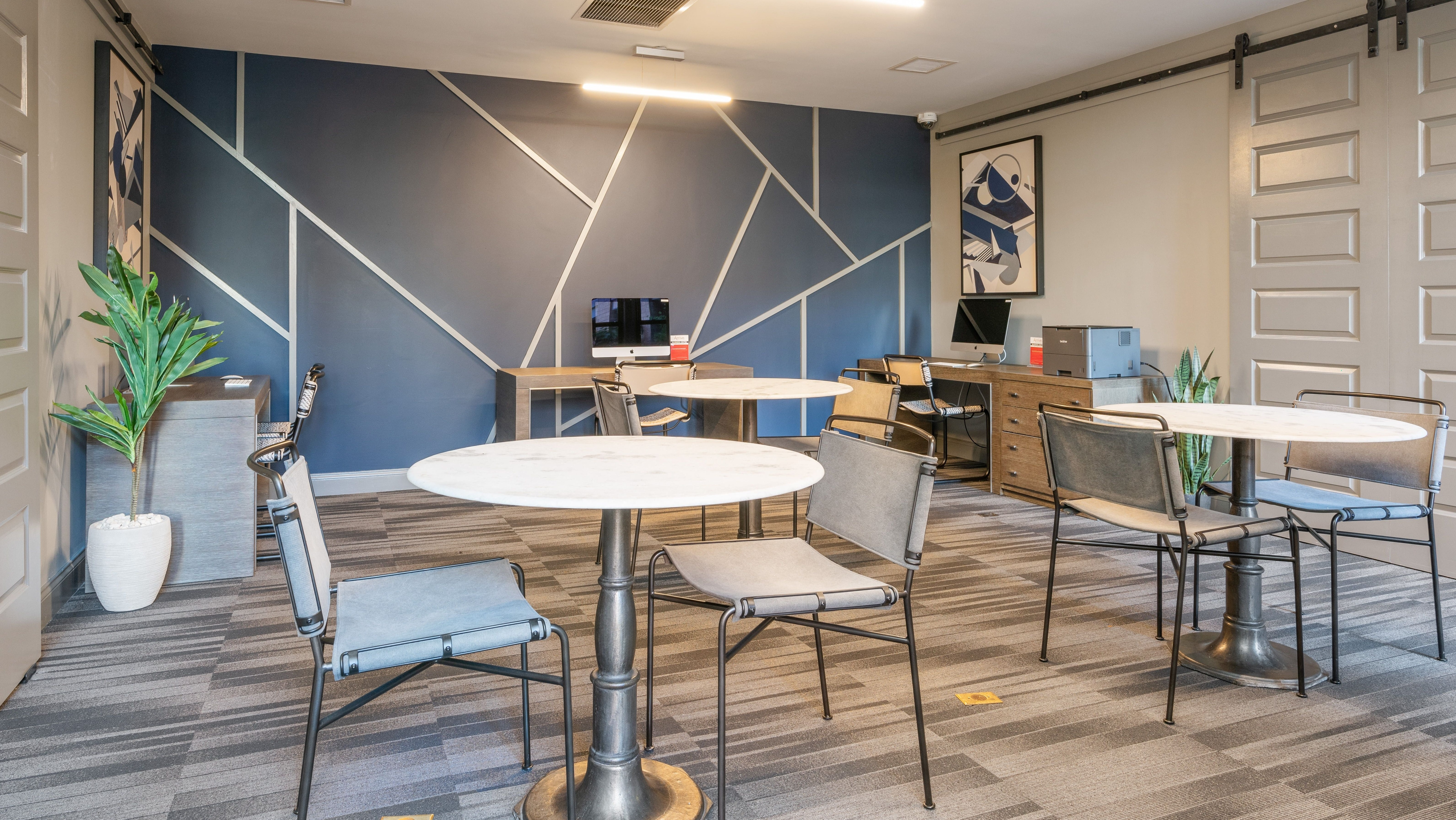Stylish resident lounge at Arrive South Loop apartments with modern tables, chairs, and dedicated workspaces in Chicago