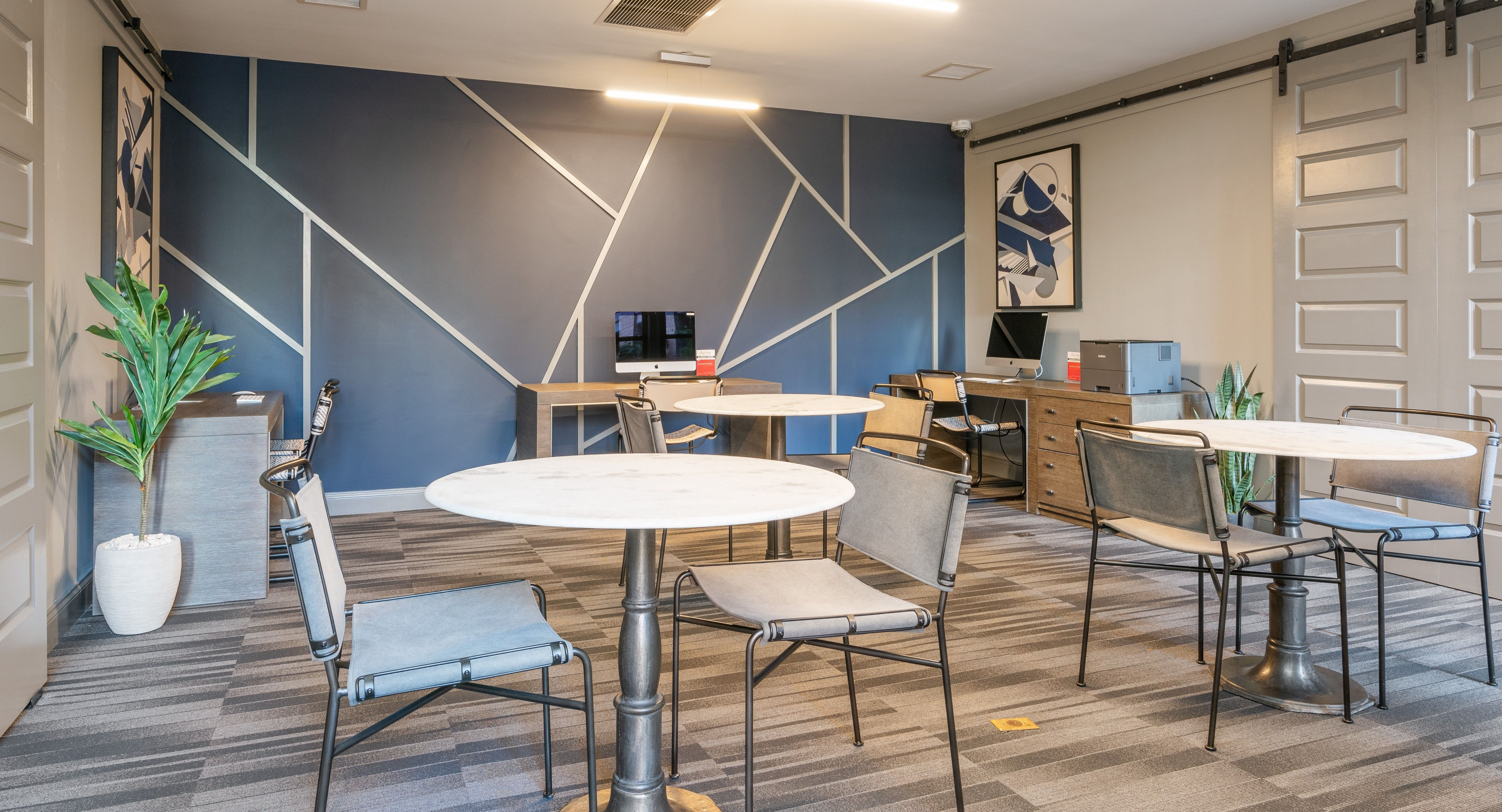 Stylish resident lounge at Arrive South Loop apartments with modern tables, chairs, and dedicated workspaces in Chicago