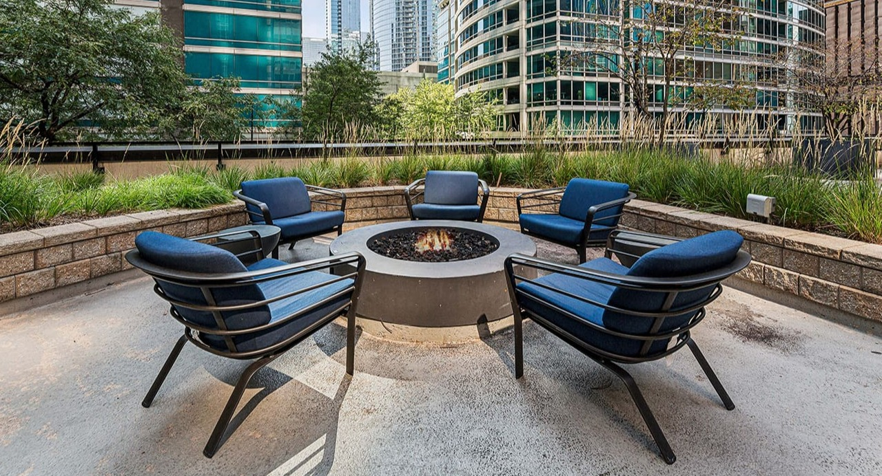 Outdoor fire pit lounge at Arrive Streeterville with comfortable seating, perfect for social gatherings