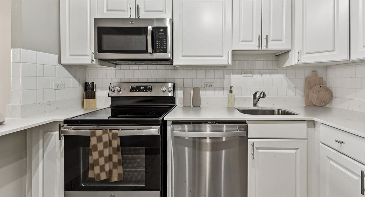Contemporary kitchen at Arrive Streeterville featuring white subway tile backsplash and modern appliances