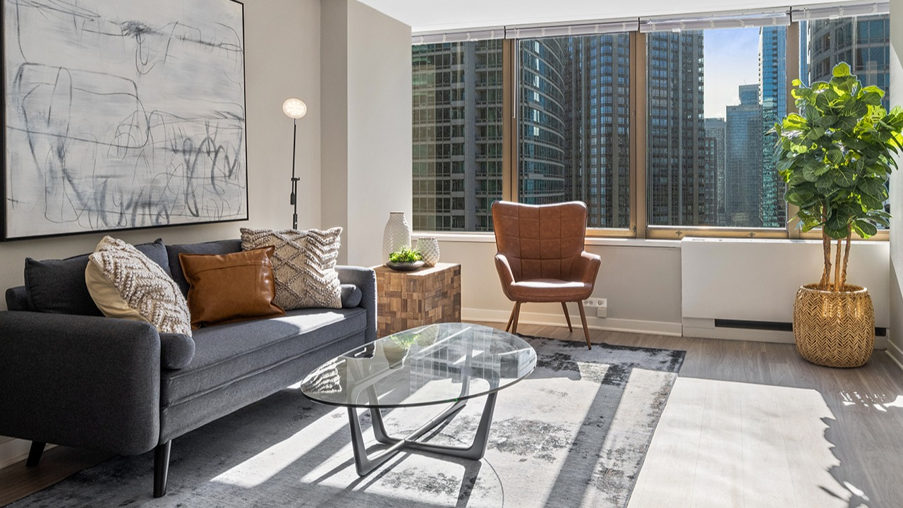 Bright and modern living room at Arrive Streeterville with stylish decor and floor-to-ceiling windows