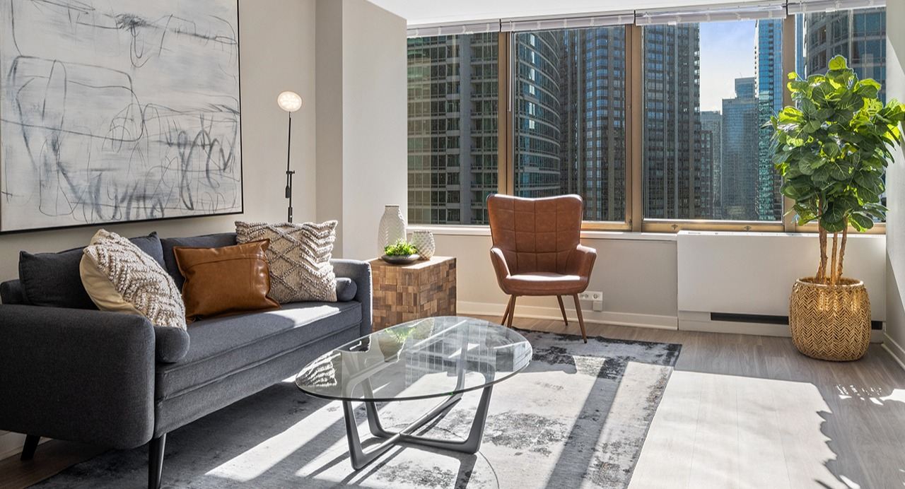 Bright and modern living room at Arrive Streeterville with stylish decor and floor-to-ceiling windows
