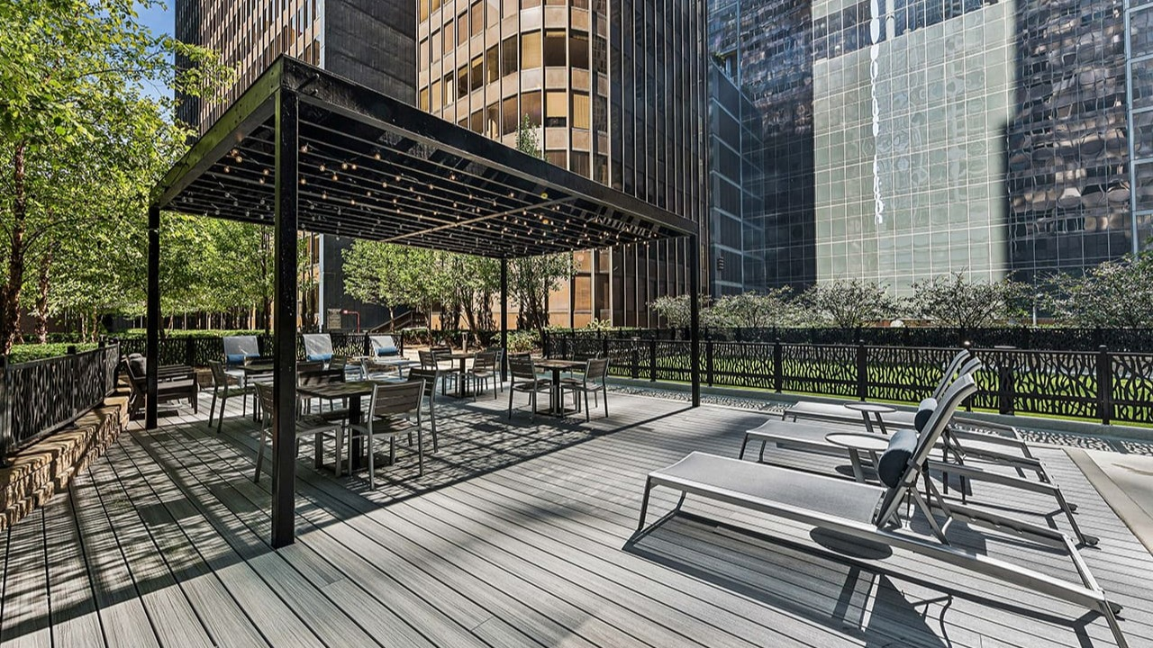Spacious outdoor sundeck at Arrive Streeterville with lounge chairs and a shaded pergola seating area