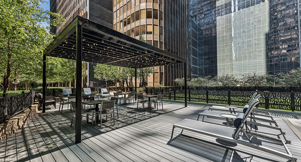 Spacious outdoor sundeck at Arrive Streeterville with lounge chairs and a shaded pergola seating area