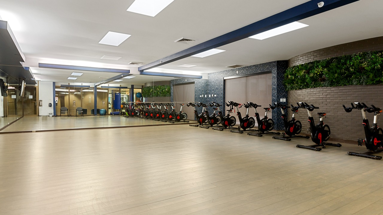 Dedicated spin and yoga studio at Arrive Streeterville with stationary bikes, mirrors, and ample floor space